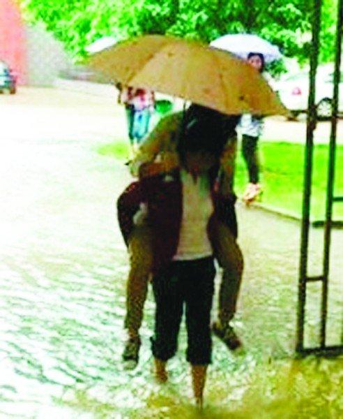 武汉暴雨：最美清洁工背女生涉水上课